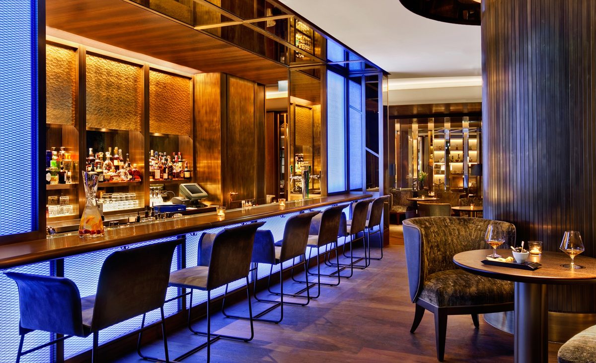 Luxus hotelbar kék LED világítással, dió bárpulttal és bársony székekkel