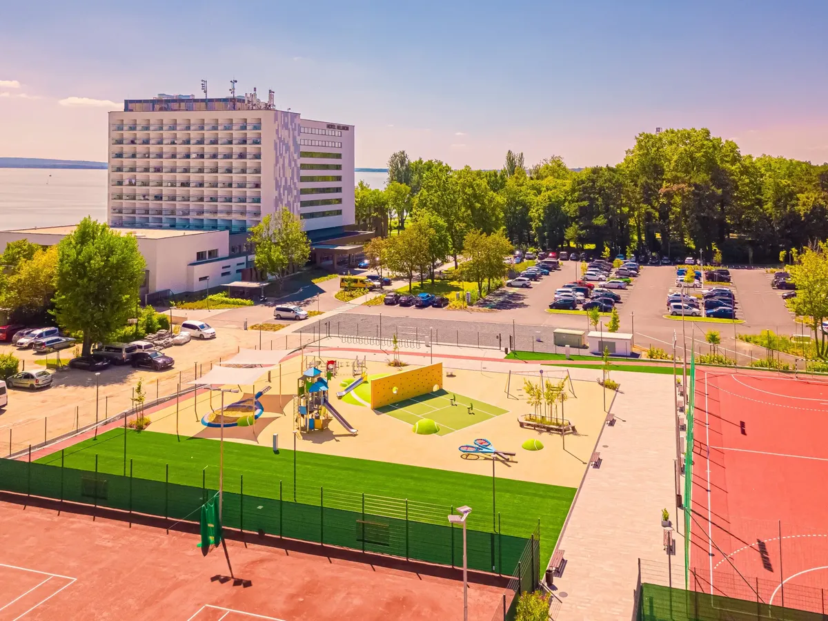 Balatoni hotel madártávlatból sportpályákkal, játszótérrel és parkolóval